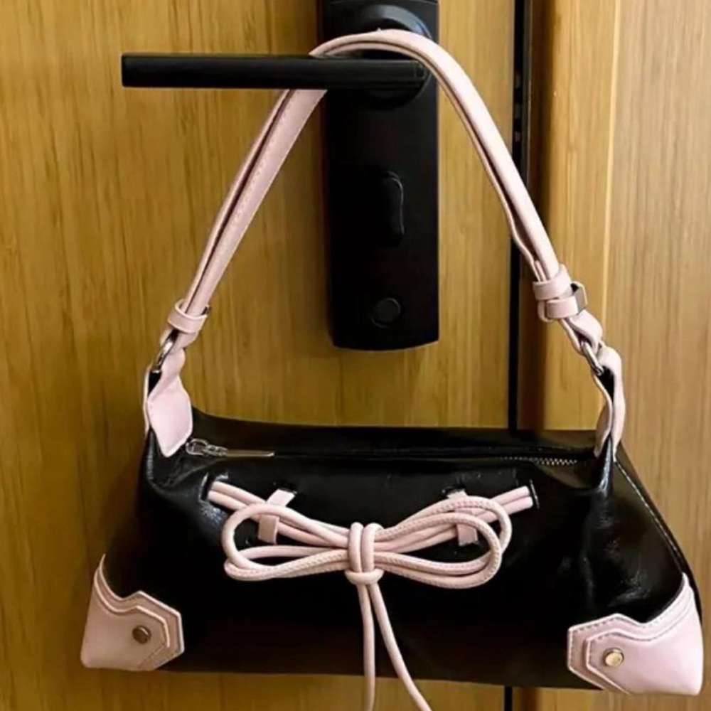 babydoll faux shoulder bag w adjustable strap. Pink bow on front of bag. 💕